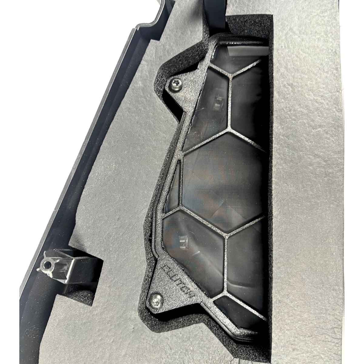 Black hexagonal grid device in dark foam packaging.