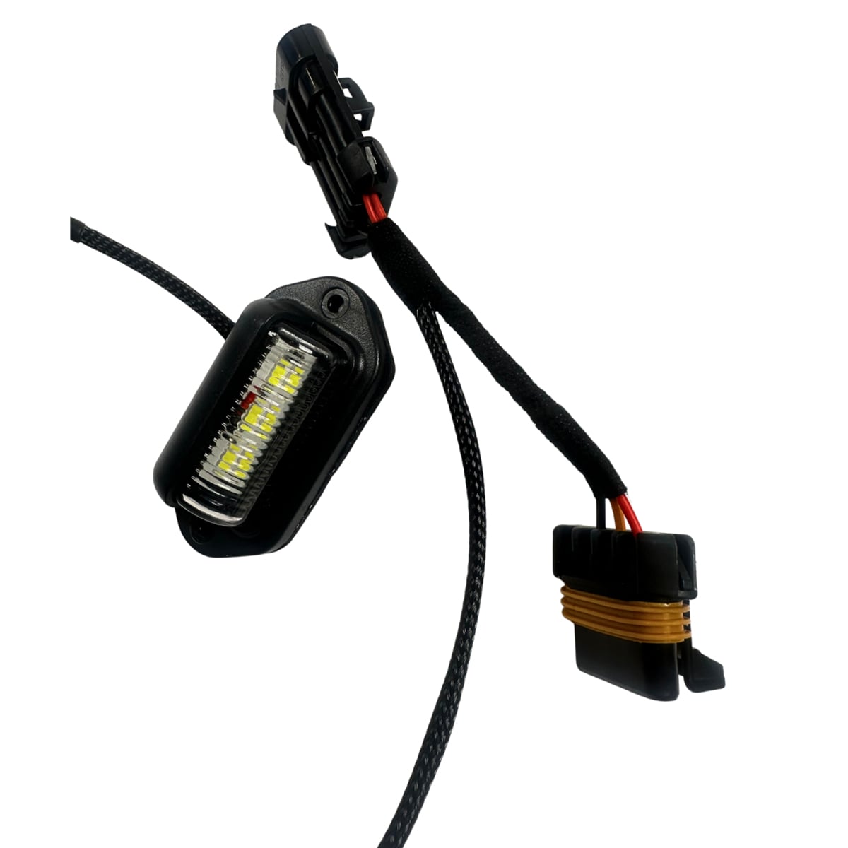 Compact automotive LED light with wiring harness and connectors.